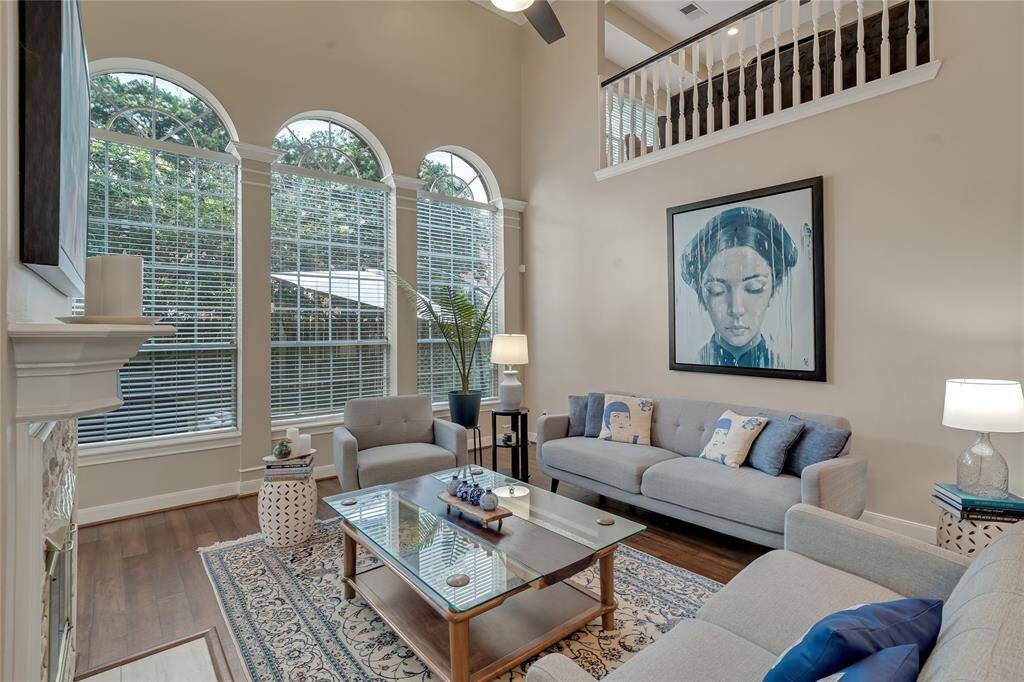 The living room has an abundance of natural light, with a wall of windows overlooking the backyard.
