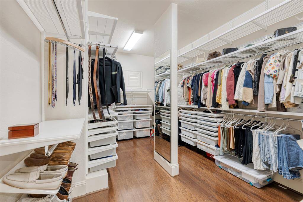 Huge walk-in closet with Elf® shelving and vanity mirror.