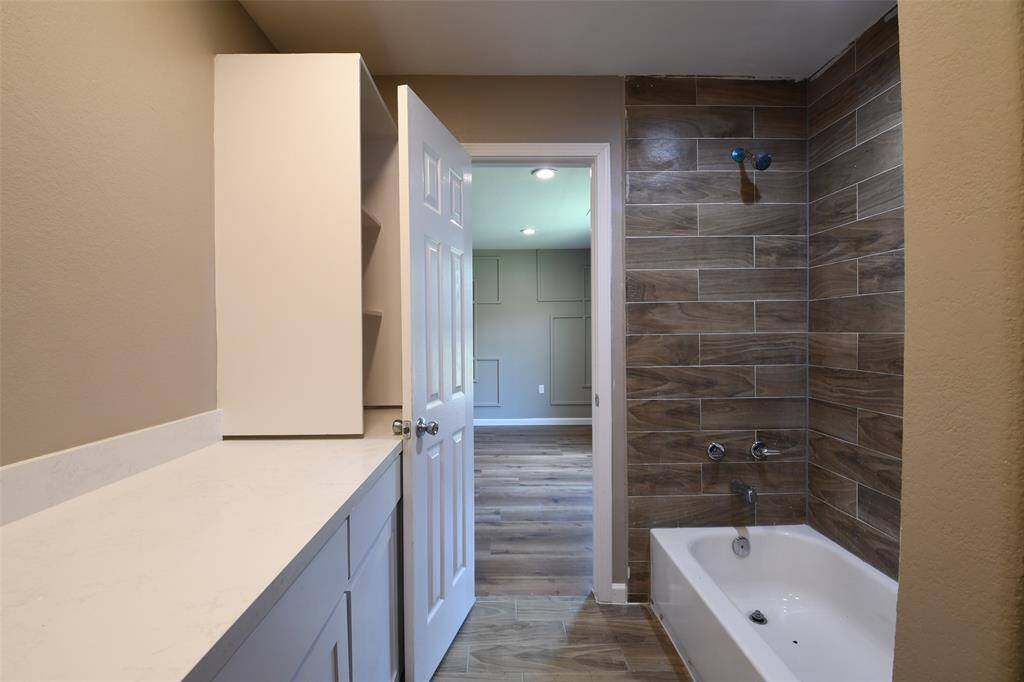 Primary bathroom includes a shower/tub combo and a spacious countertop.