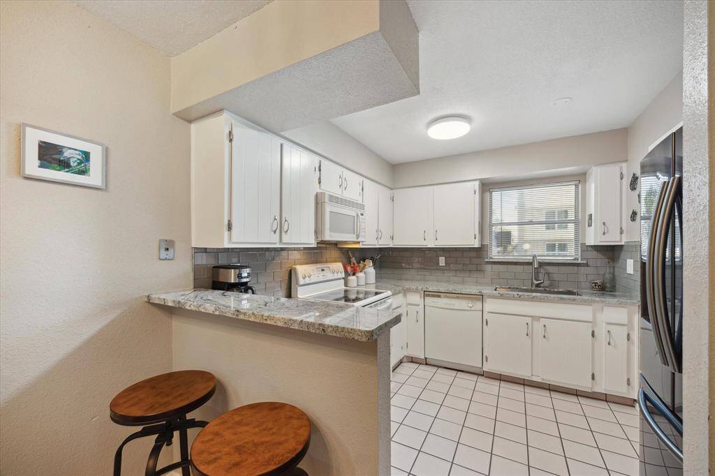 The kitchen area has a peninsula bar with room for two barstools.