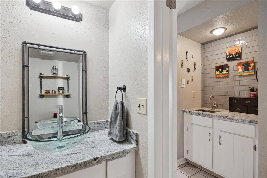 There is a spacious powder Room on your bottom floor. Convenient  for you or your guests. This powder room also boast the beautiful updated granite and a custom designer sink.