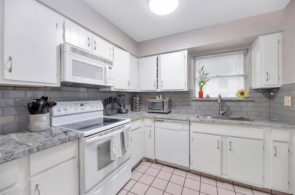 This kitchen has been updated with a beautiful gray and white quartz, and glossy gray subway tile backsplash. Cabinets were painted a fresh white.New current photos coming soon!