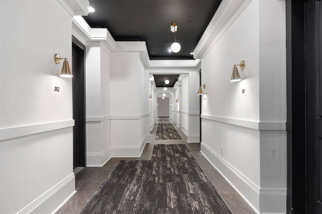 Main hallway to condo has new carpeting, paint and light fixtures.