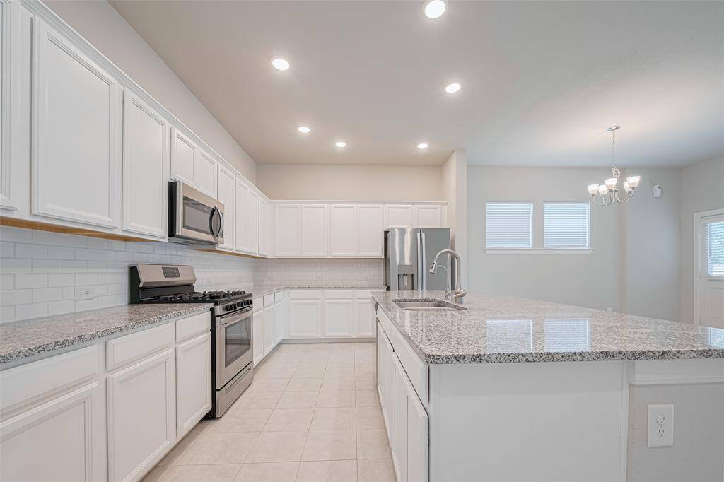 Spacious kitchen with granite countertops, stainless steel appliances and a large island with additional seating. Refrigerator conveys!