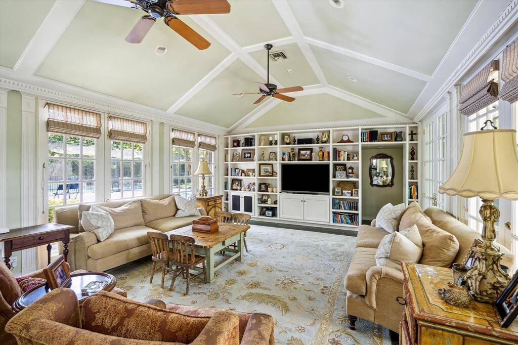 The great room or family room is approximately 25' x 16' with walls of French doors and window on both sides.  One with view to the pool and backyard gardens to the east and a view of the charming side garden to the west.