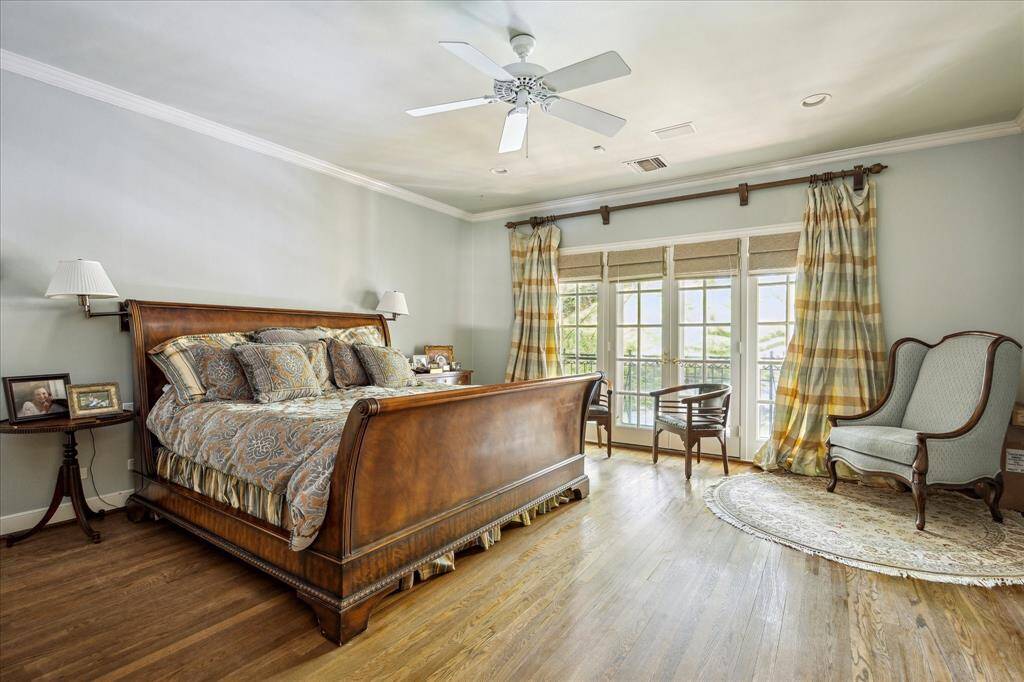 The primary bedroom with view to the backyard gardens and pool.