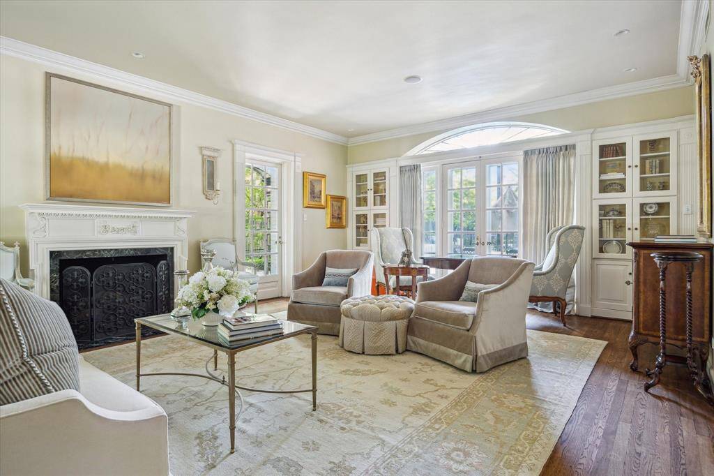 There are French door on either side of the wood burning fireplace that lead to a covered patio, gardens and fountain.  The fountain may need to be re-worked.  There is also another set of French doors with the fabulous original screen doors that lead to the backyard gardens and pool.