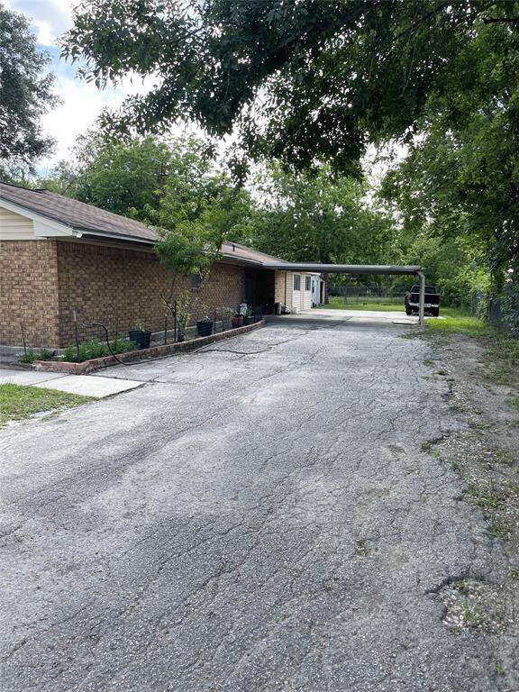 Spacious driveway offering ample parking and easy access to the home, surrounded by greenery for added privacy.
