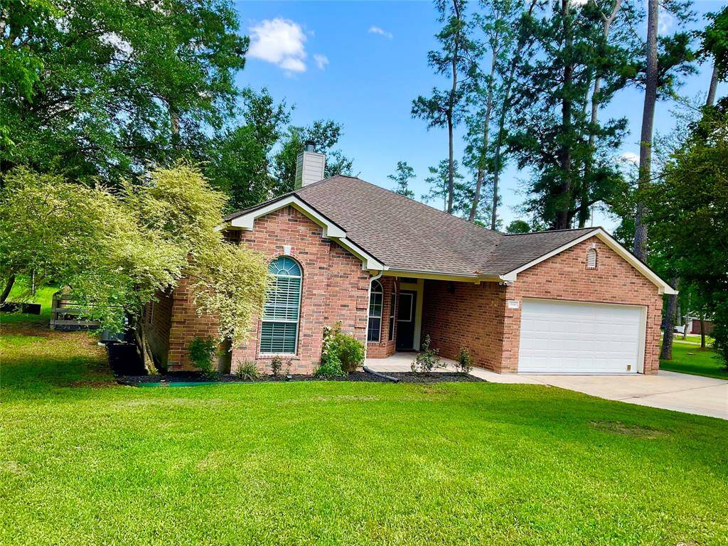 Charming single-story brick home with a gabled roof and attached two-car garage. It features a well-maintained front lawn and is surrounded by mature trees, offering a serene, private feel. Perfect for those seeking a cozy, inviting residence in a lush setting. The lot next door is for sale as well for your own enjoyment, to build or investment.
