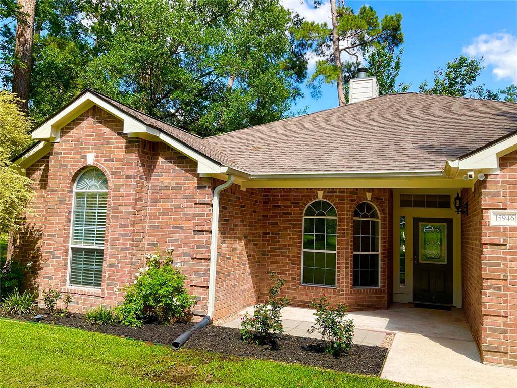 Charming brick home with a welcoming front porch, arched windows, and a well-maintained lawn. Surrounded by lush greenery, it offers a cozy and inviting entrance. The roof was replaced in 2016.