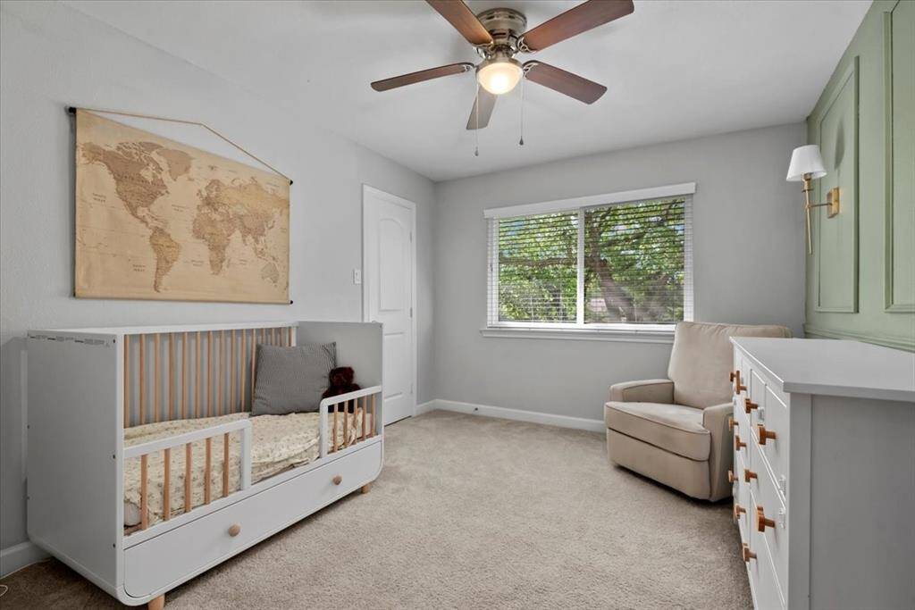 The secondary bedroom features an accent wall with gold accent sconces.
