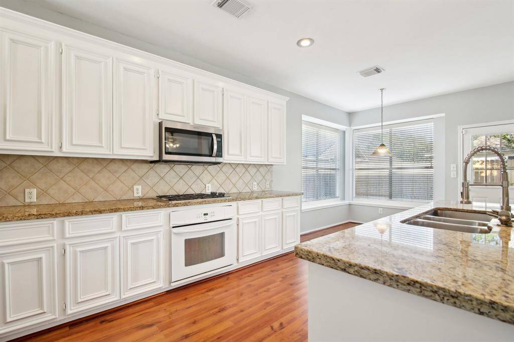Beautiful kitchen with granite countertops and white cabinetry!
