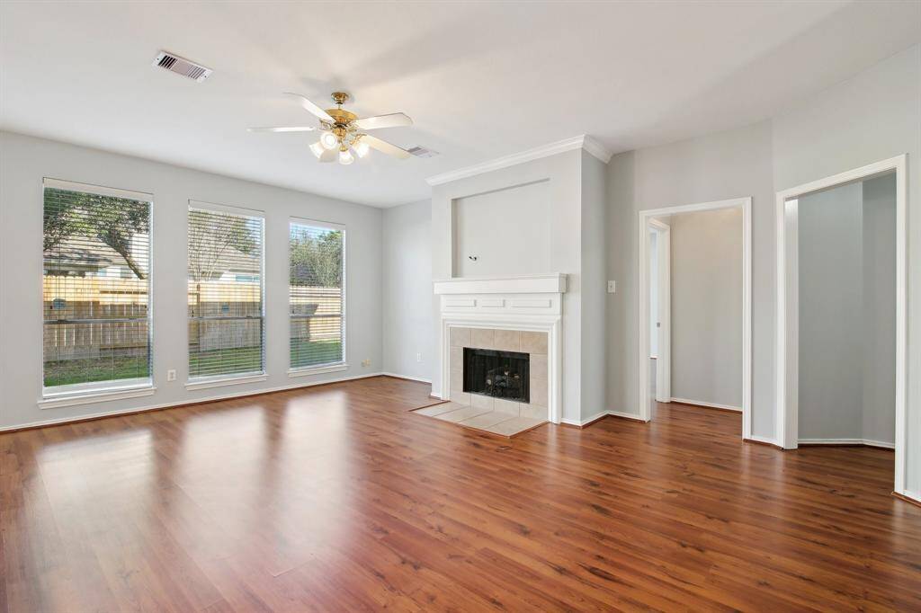 Open living area with a cozy fireplace and big windows for natural lighting!