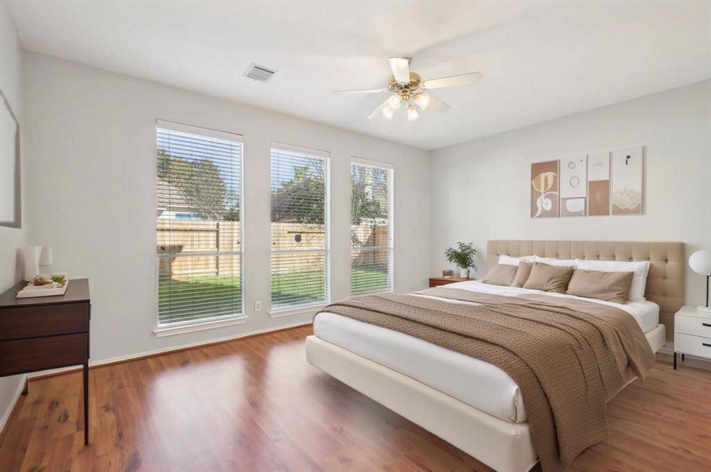 Primary bedroom with a view of the backyard. [virtually staged]