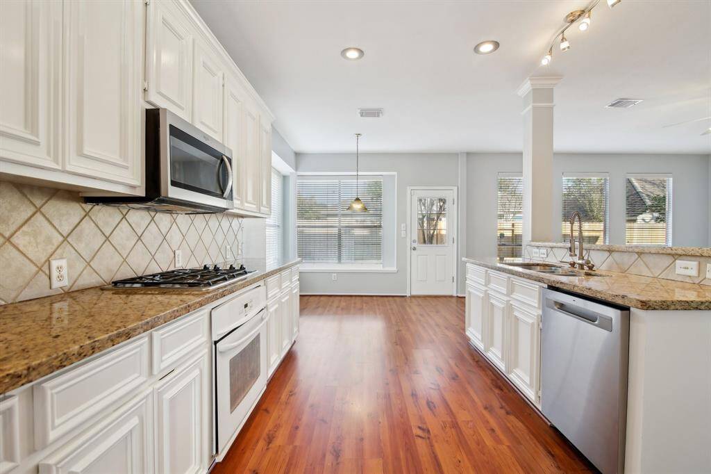 Beautiful kitchen with granite countertops and white cabinetry!