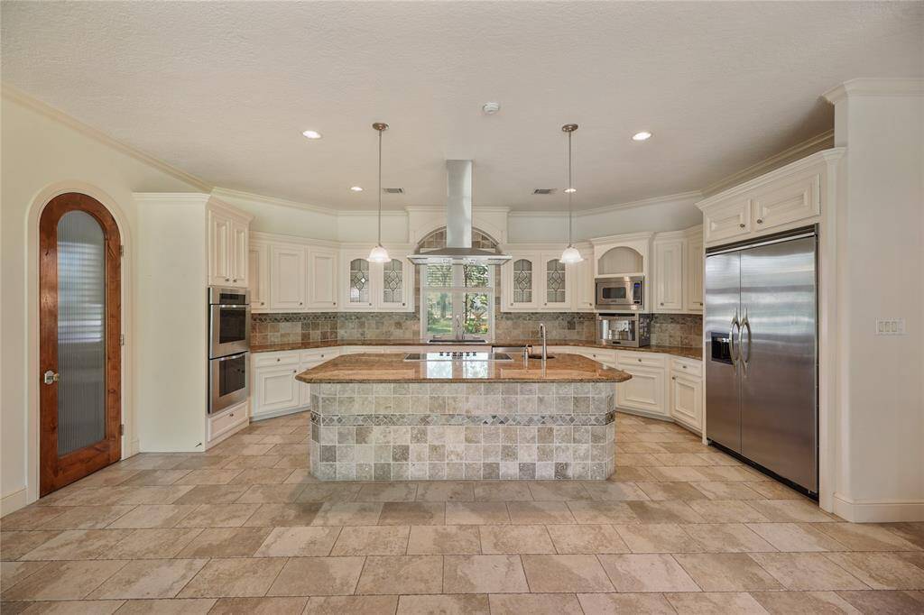 Chef's kitchen showcasing top-of-the-line appliances, double ovens, and an oversized island - perfect for culinary creations and effortless entertaining