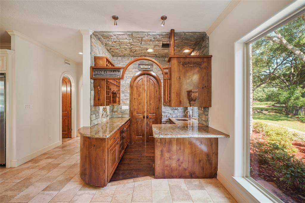 Entertain in style with this sophisticated bar and wine area, featuring a wine fridge, ice maker, sink and custom cabinetry - the perfect blend of luxury and convenience