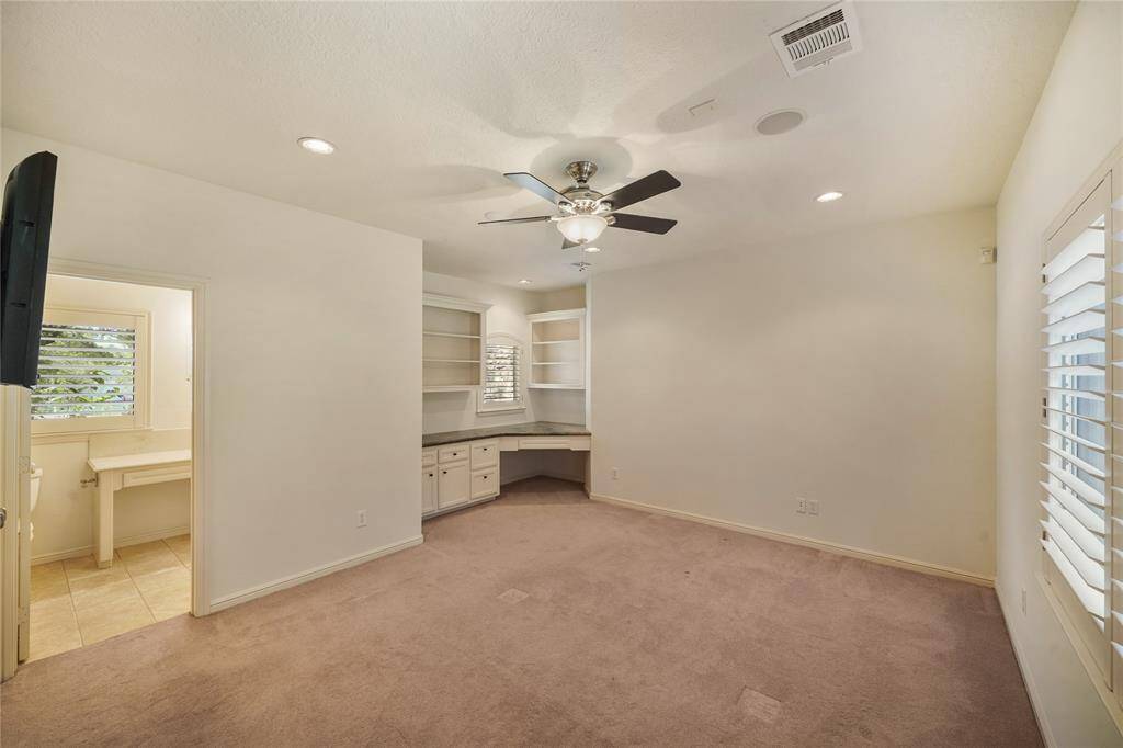 Upstairs bedroom 20'7" x 15'5" featuring a custom-built desk, paired with a private en suite bathroom - a perfect blend of function and comfort