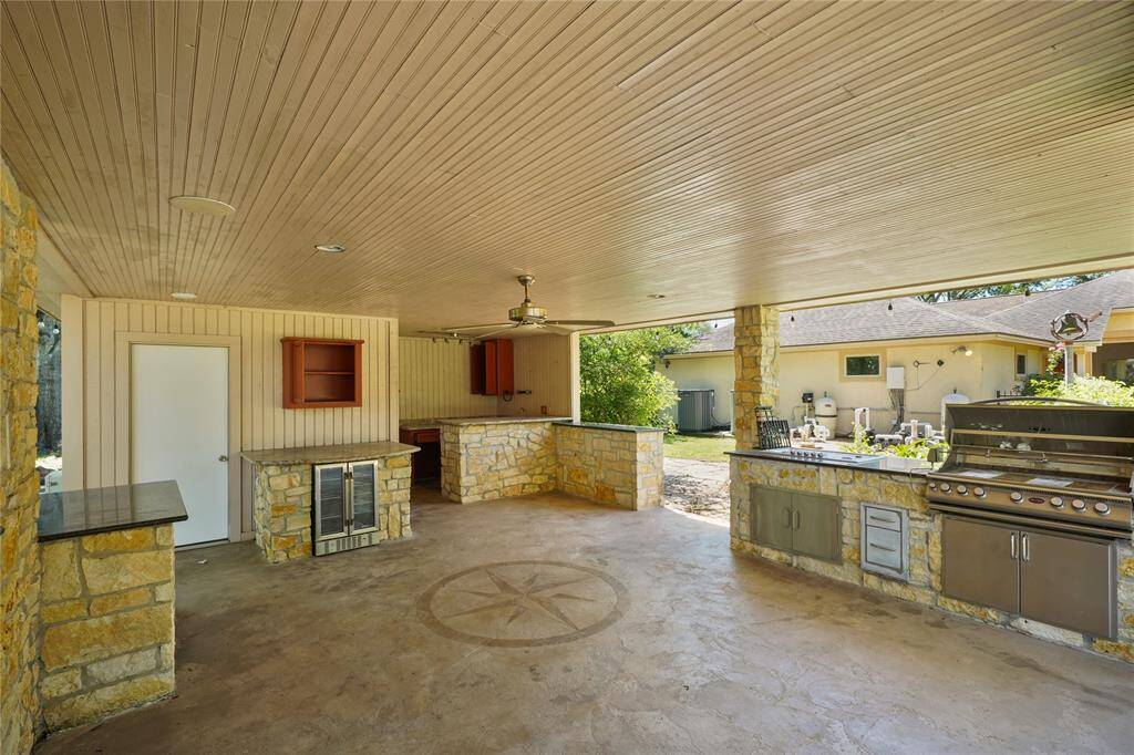 Fully equipped cabana with a stone wood-burning fireplace, outdoor kitchen, full bathroom, and TV - the perfect spot for year-round enjoyment