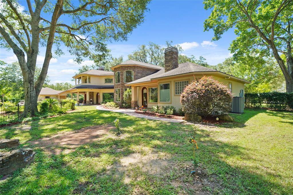 Lush backyard featuring newly planted fruit trees - adding charm and potential to the serene outdoor setting behind this stunning home