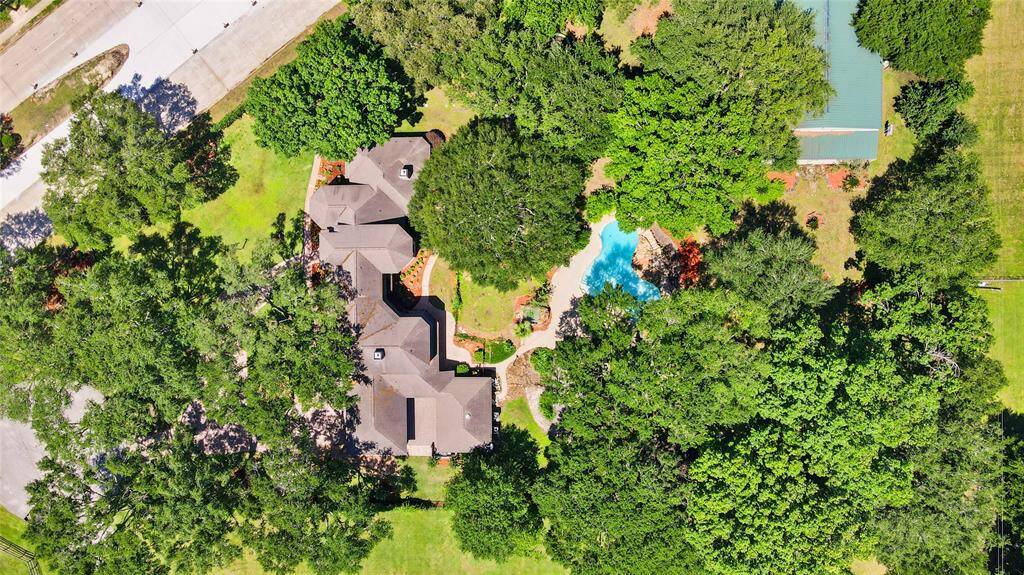 Breathtaking aerial view of this expansive estate, capturing the stunning home nestled on 2.4 acres of lush, private land - a true oasis offering both luxury and space