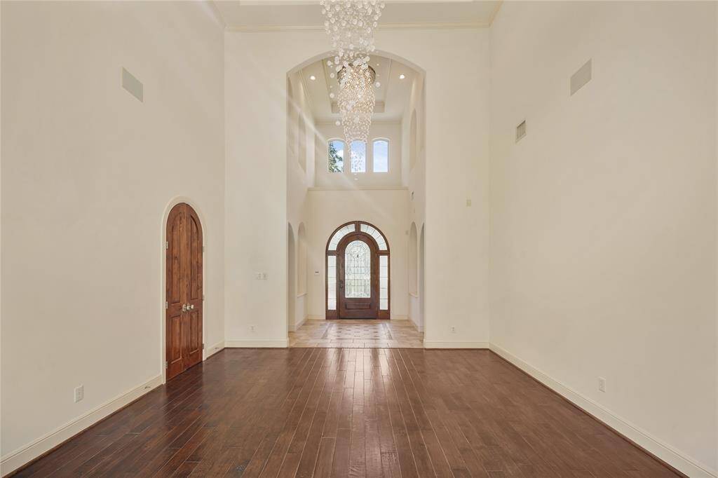 Dramatic high ceilings in the foyer and dining room are complemented by stunning custom chandeliers - creating an unforgettable first impression