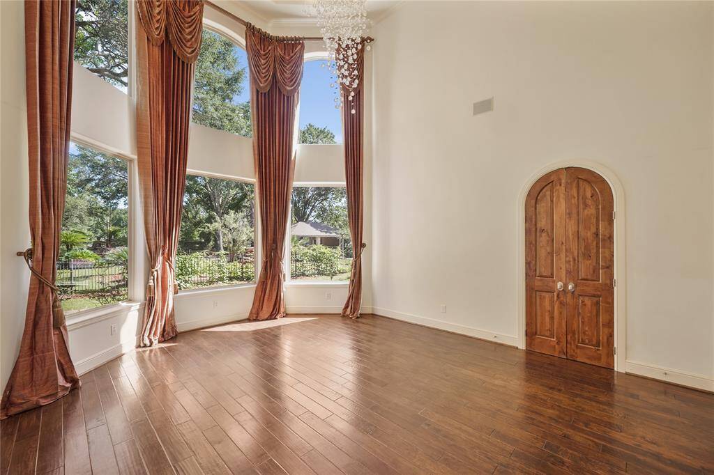 Expansive windows in the dining room frame picturesque views of the beautifully landscaped backyard, filling the space with natural light and serene ambiance