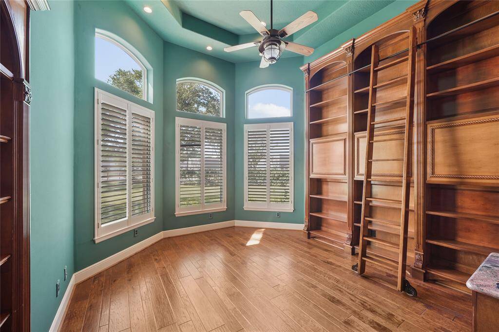 Refined home office featuring a built-in library with a classic rolling ladder- perfect for work, study, or quiet reading in a space with timeless charm