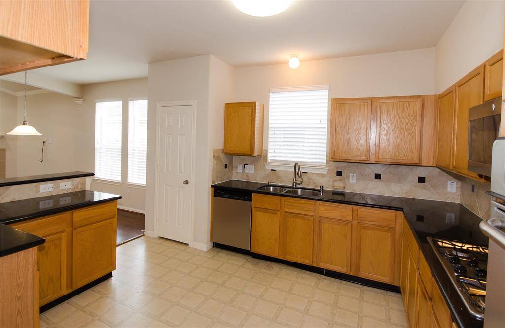 Granite counter tops, has stove top, plenty of cabinet space and open to the bright living room. There is plenty of space to walk around in here.