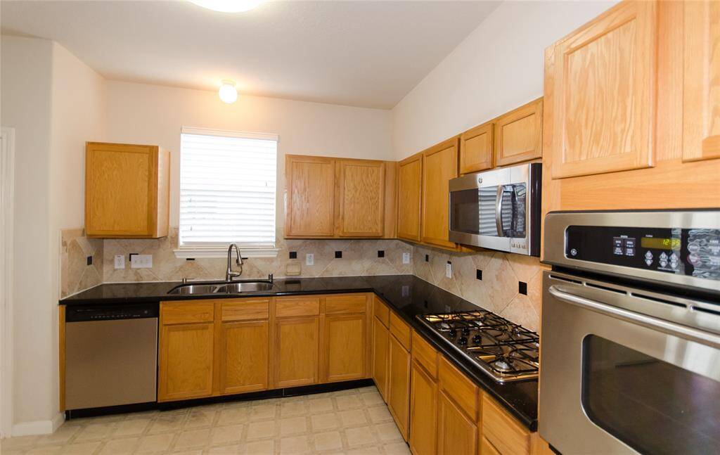 Stainless steel appliances with updated backsplash. A raised oven that won't have you bending down to look at what is cooking.