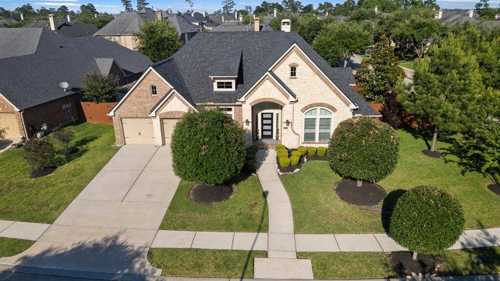 This charming home features a classic brick exterior with a well-maintained front lawn and manicured shrubs. It includes a three-car garage and a welcoming entrance with a pathway. Located in a quiet neighborhood, this property offers a blend of comfort and curb appeal.