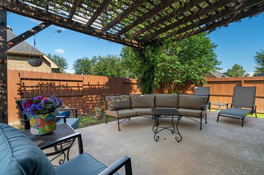 This charming backyard boasts a spacious patio with a pergola, cozy seating, and a vibrant garden—perfect for relaxation and entertainment.