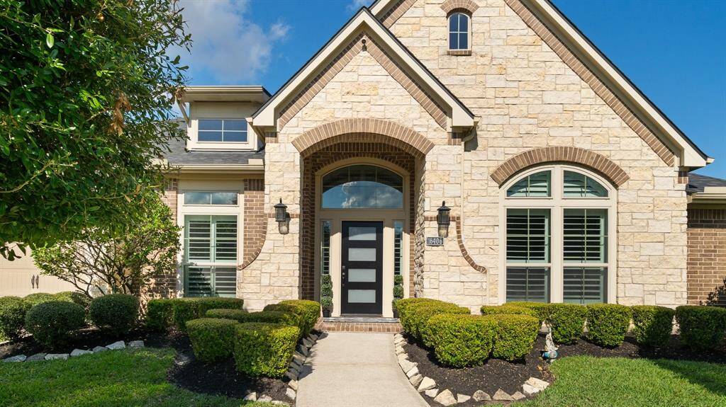 Features large arched windows with shutters, manicured shrubs, and a well-maintained path. Ideal for buyers seeking curb appeal.