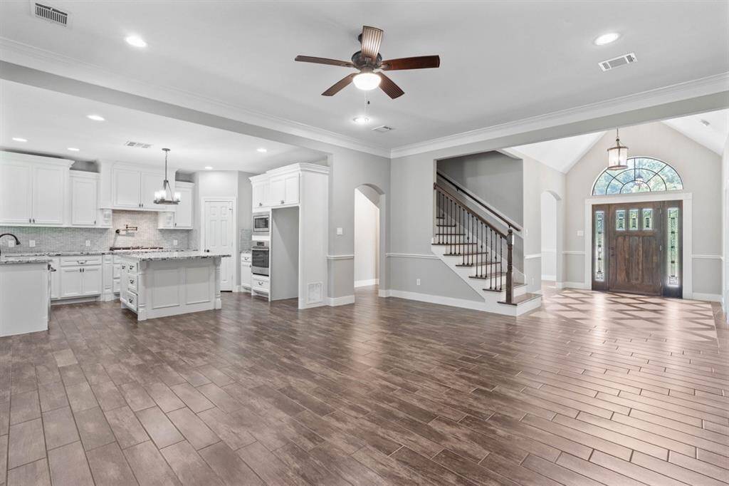 Looking into the kitchen, foyer and entryway into the formal dining.  This home is a dream come true to those who like to entertain! This open concept allows everyone to part of the conversation.  Notice how beautiful the "wood look" title floors are.
