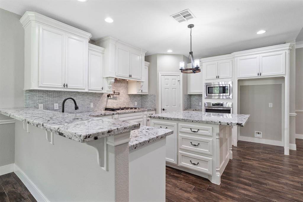 Not only is this kitchen a chef's dream with the walled microwave and oven, to the walk-in pantry and pot filler over the gas cooktop, but the granite counter space allows ample room to spread all the ingredients out, display the meal and offers extra seating around the island and bar.