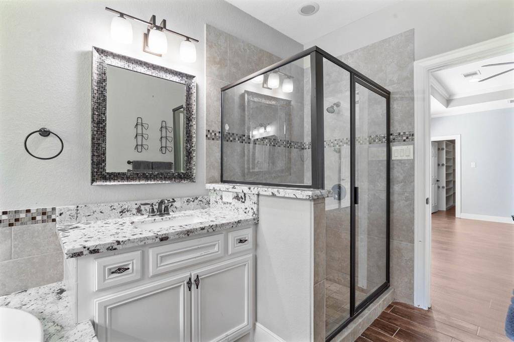 View of the standalone shower and looking out to the primary bedroom.