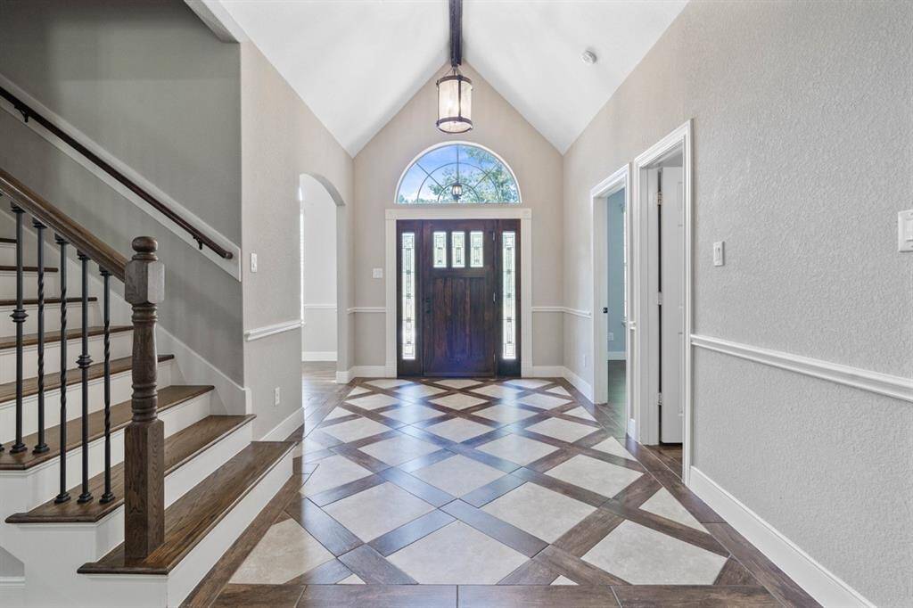 Look at this stunning entrance!! From the cathedral ceiling featuring a wood beam to the unique floor design it is sure to be a conversation piece and a show shopper. But wait, there is so much more...