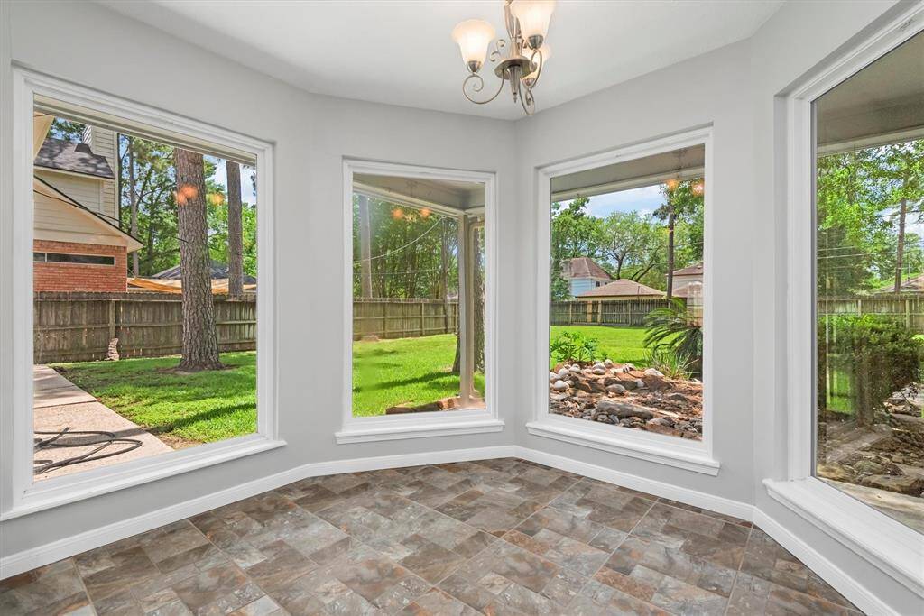 This bright and cheerful breakfast nook features stunning bay windows that overlook the spacious backyard, bringing in natural light and serene views to start your day.