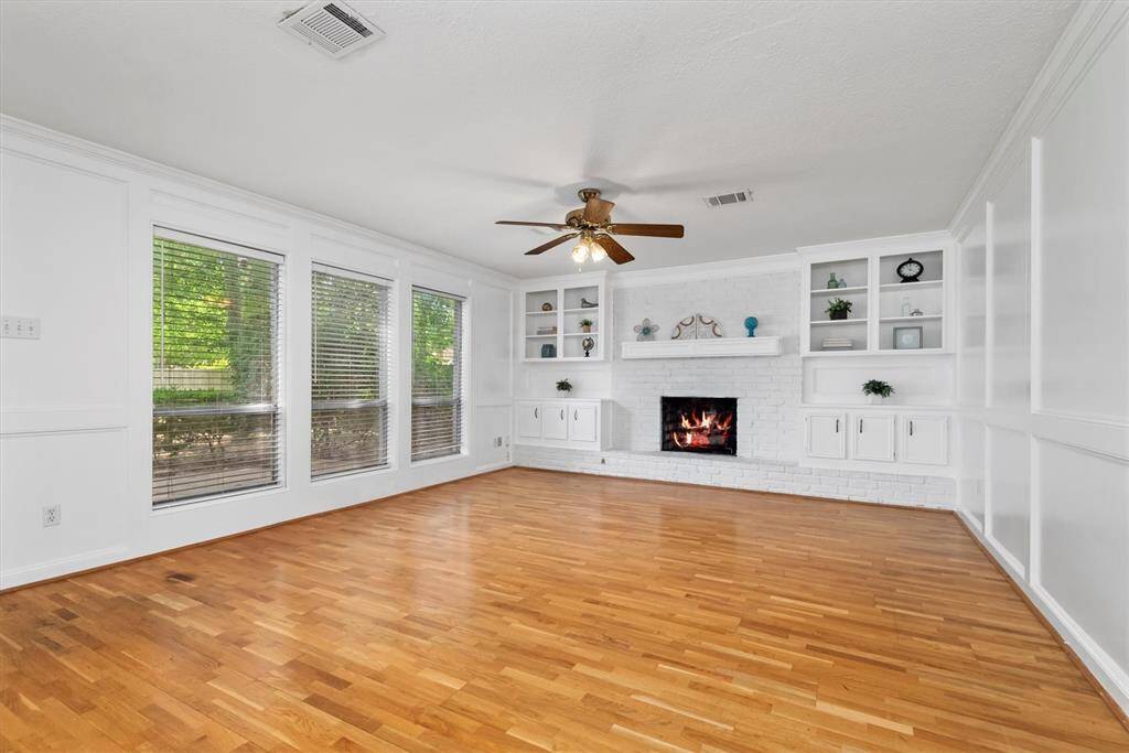 Back to the main living area. You will notice a wall of custom built-ins as well as the gorgeous natural wood flooring.