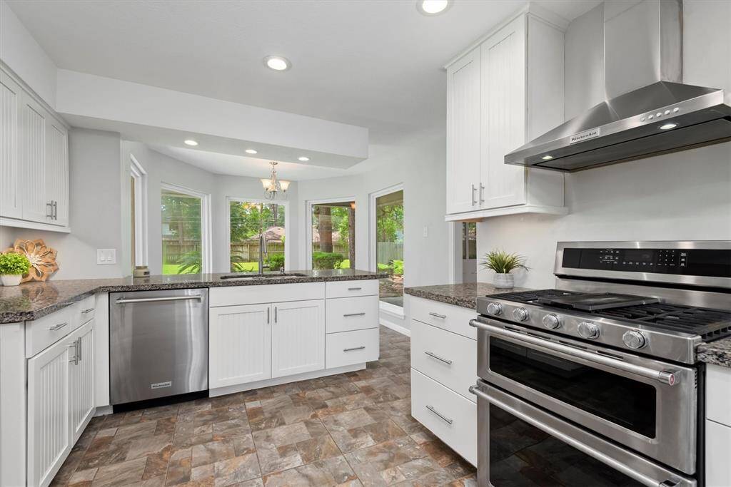 This light and bright updated kitchen boasts granite countertops, double ovens, and a gas cooktop with beautiful views of the backyard.
