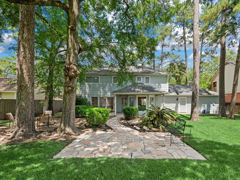 This expansive backyard features a sitting area, fire pit, and covered patio, perfect for outdoor gatherings and relaxation.