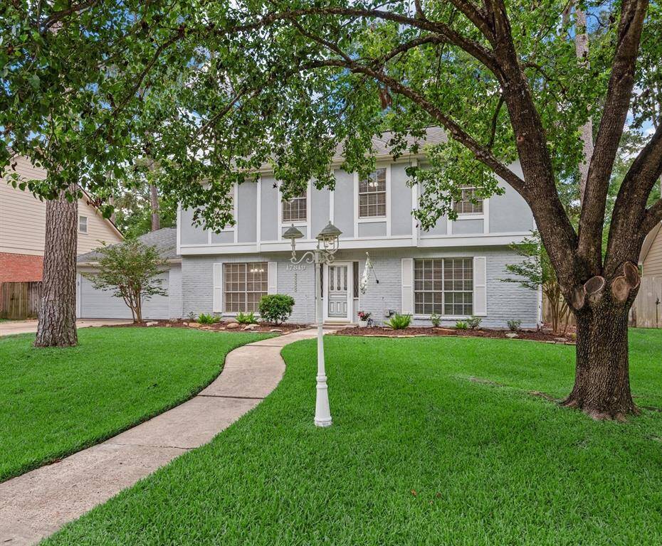 Charming front yard with classic curb appeal featuring a picturesque lamp post, mature trees, and a welcoming walkway that adds timeless character.