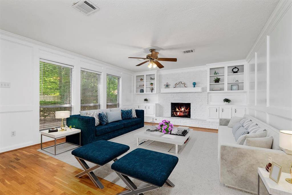 This spacious living area with a gas log fireplace, wood flooring, and natural light is large enough to hold all of your living room furnishings. Virtually staged.