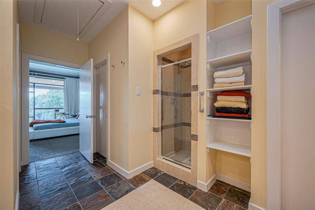 The large walk-in closet in the primary bedroom is the third closet, which has additional shoe shelves behind the door.