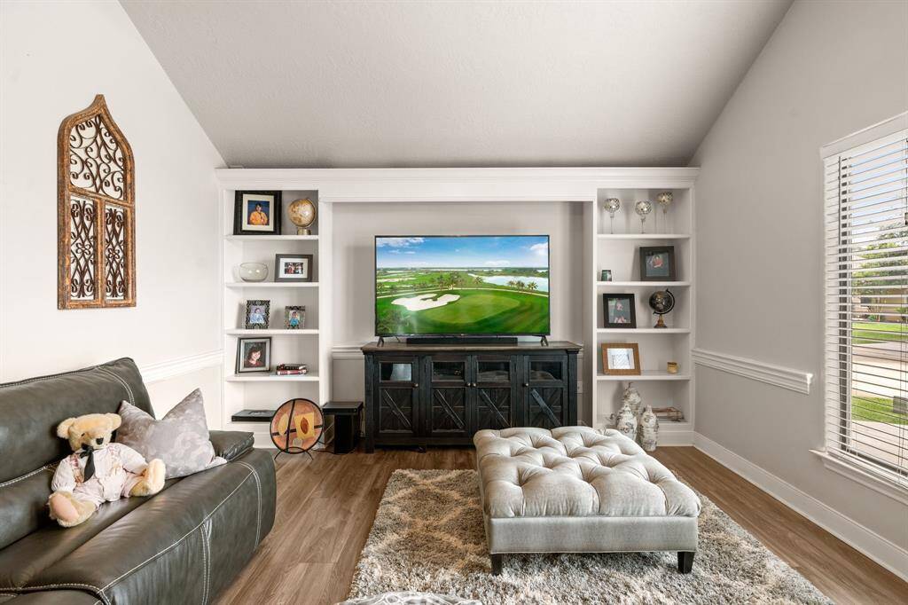 The den! Wonderful space to hang out and watch some tv. Lovely built-ins surrounding TV. This view is from the entry.