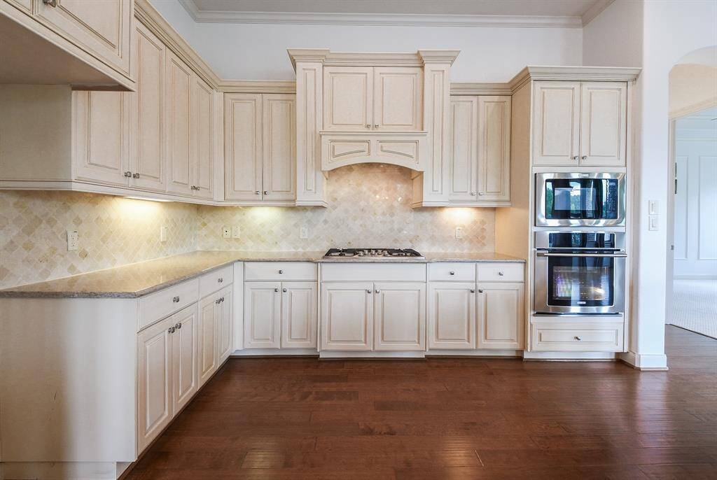 Gorgeous, muted, matte sand colored cabinetry is everywhere you need it to be; complemented by luscious granite countertops and pale tile backsplash.