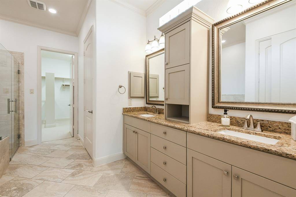 It's so relaxing just walking into this amazing primary ensuite bath! Dual sinks are nicely placed for personal rhythms, with gorgeous cabinetry storage below (and on center counter, above) with sophisticated framed wall mirrors, tons of tiled floor space, and in this view, a look, up left center, into an unbelievable walk-in closet.
