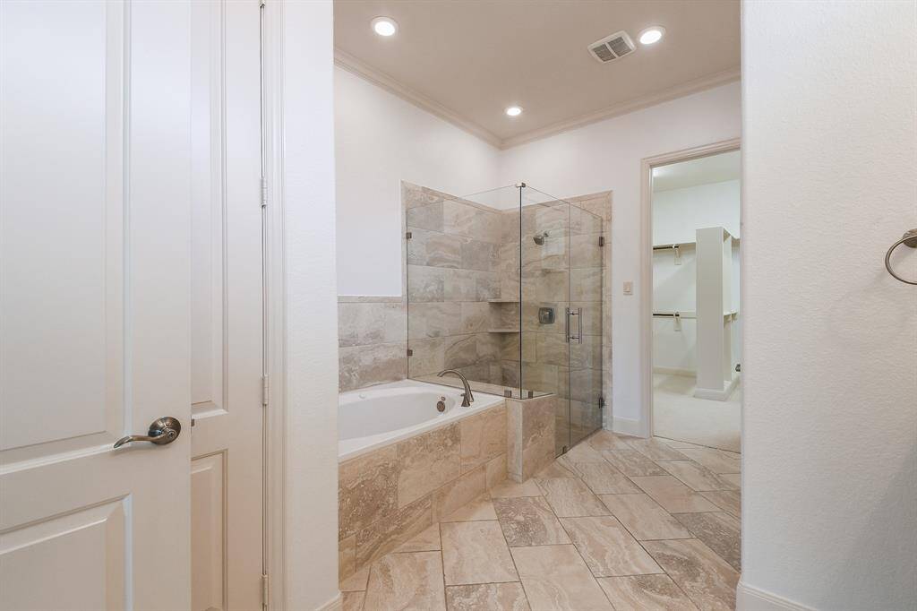 Sleek simplicity defines the placement of the walk-in, rimless shower and garden tub, side-by-side.