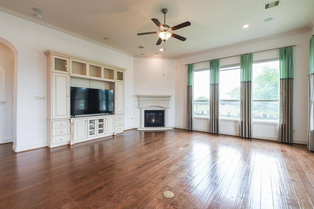 This amazing living space is one you won't often see! High ceiling, wood flooring, a wall of windows overlooking a placid lake; amazing built-in wall unit, and space, galore. And, oh, yes! The corner gas connected fireplace is sure to be the star of the show in any season.