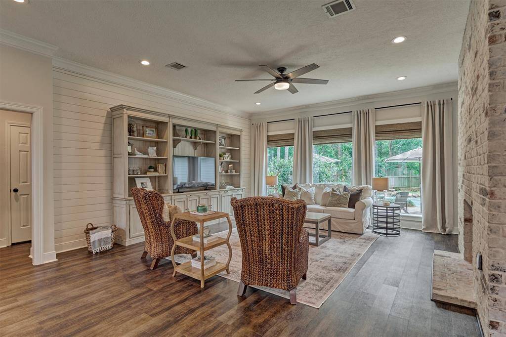 Family room with double-sided gas log fireplace and view of back yard oasis.